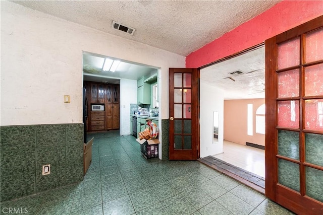 hallway featuring tile patterned floors and a textured ceiling