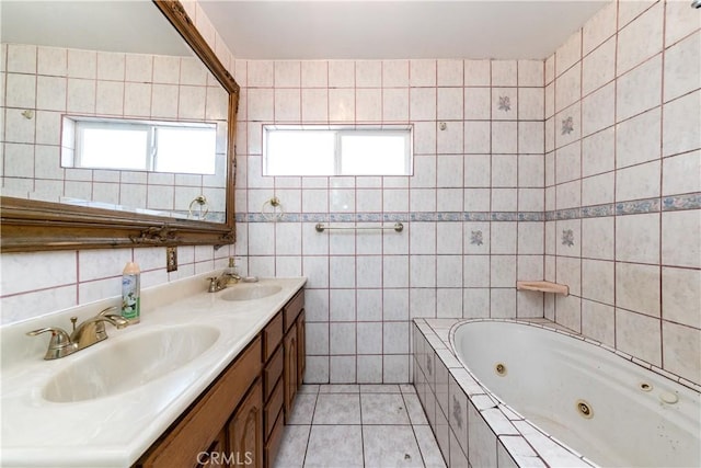 bathroom with a relaxing tiled tub, vanity, tile patterned floors, and tile walls