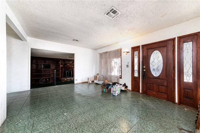 foyer featuring a fireplace and a textured ceiling