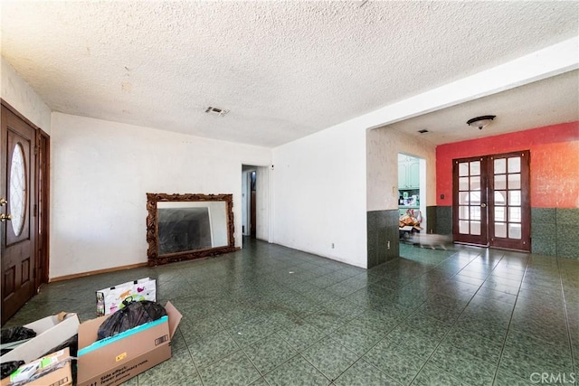 living room featuring french doors and a textured ceiling