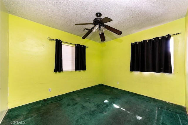 carpeted spare room with ceiling fan and a textured ceiling