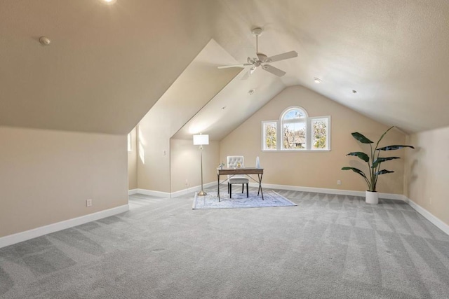 interior space with ceiling fan, light colored carpet, and vaulted ceiling