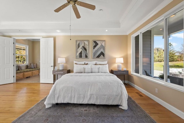 bedroom with multiple windows, ornamental molding, and hardwood / wood-style floors