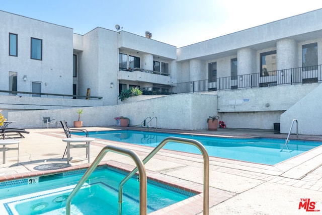 view of pool featuring a patio and a community hot tub