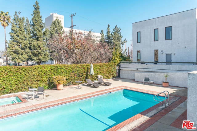 view of pool with an in ground hot tub and a patio area