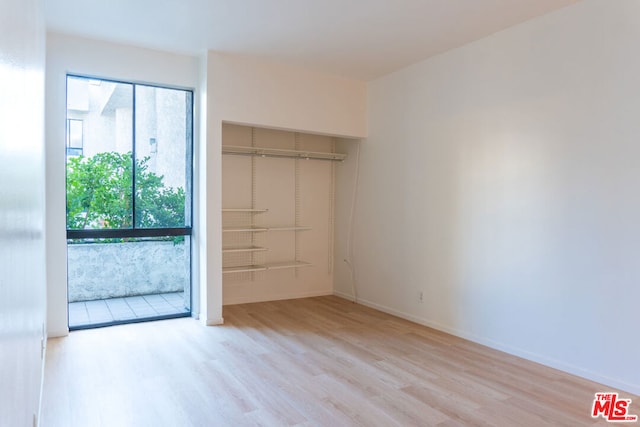 unfurnished bedroom with light wood-type flooring and a closet