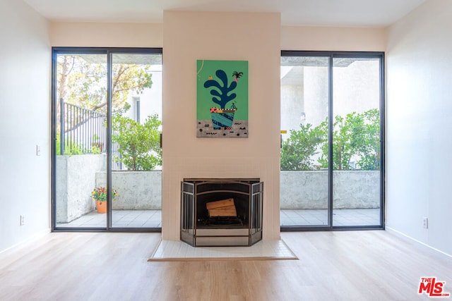 unfurnished living room featuring a healthy amount of sunlight and hardwood / wood-style floors