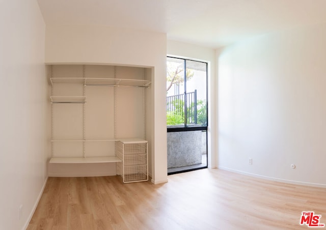 unfurnished bedroom featuring light wood-type flooring and access to outside