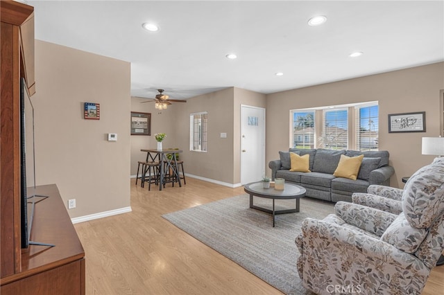 living room featuring ceiling fan and light wood-type flooring