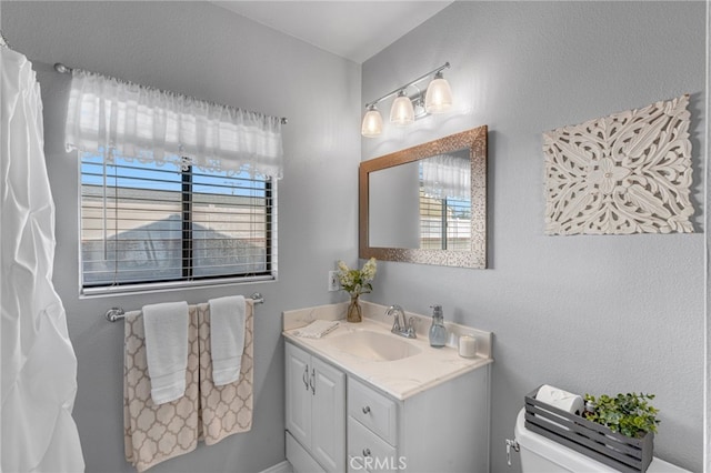 bathroom featuring vanity, plenty of natural light, and toilet