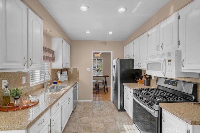 kitchen featuring appliances with stainless steel finishes, sink, and white cabinets