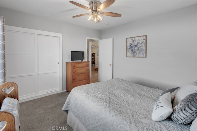 carpeted bedroom with ceiling fan and a closet