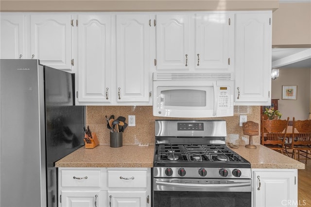 kitchen featuring white cabinetry, appliances with stainless steel finishes, and tasteful backsplash