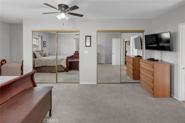 carpeted bedroom with multiple closets and ceiling fan