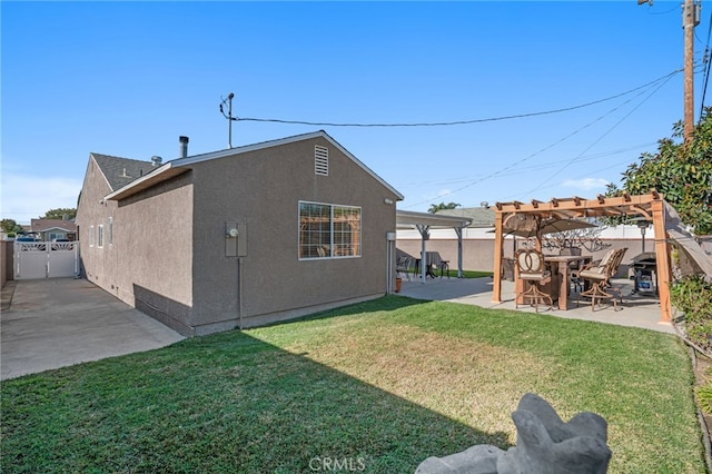 rear view of property featuring a yard, a pergola, and a patio