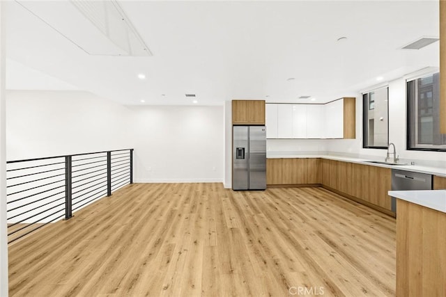 kitchen featuring white cabinetry, sink, light wood-type flooring, and stainless steel refrigerator with ice dispenser