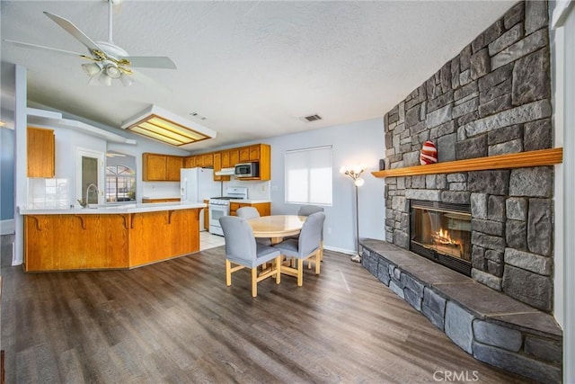 dining space featuring a fireplace, dark hardwood / wood-style flooring, and a textured ceiling