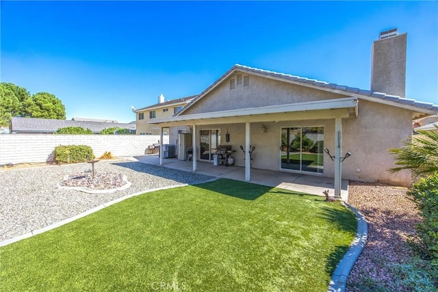 back of house featuring a patio and a lawn