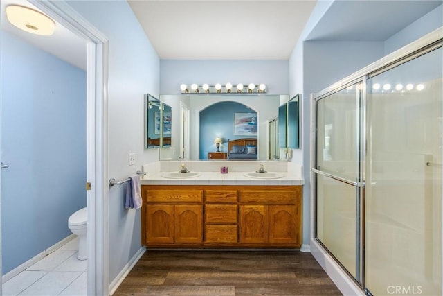 bathroom featuring vanity, toilet, a shower with door, and hardwood / wood-style floors