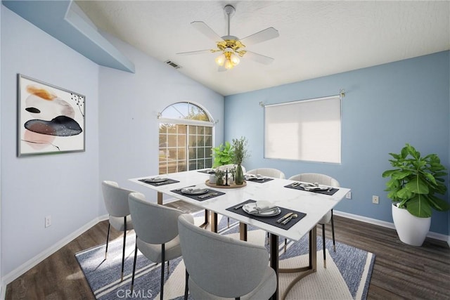 dining area featuring vaulted ceiling, ceiling fan, and dark hardwood / wood-style flooring