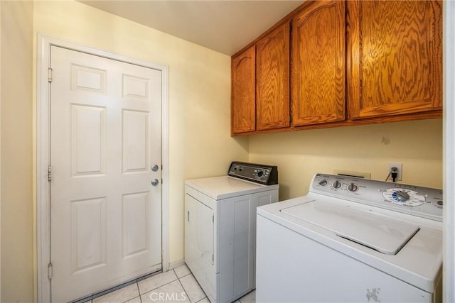 laundry room featuring cabinets, light tile patterned floors, and independent washer and dryer