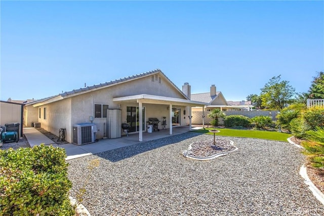 rear view of house featuring cooling unit and a patio