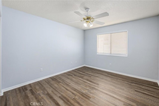 empty room with dark wood-type flooring and ceiling fan