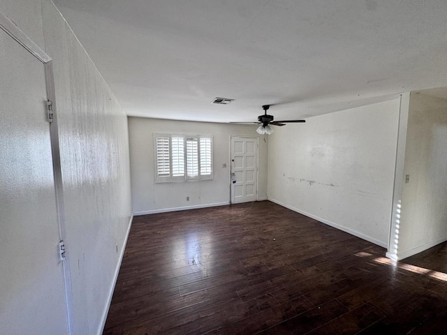 spare room with dark wood-type flooring and ceiling fan