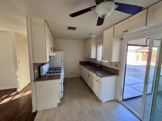 kitchen with sink, gas range gas stove, ceiling fan, light hardwood / wood-style floors, and white cabinets