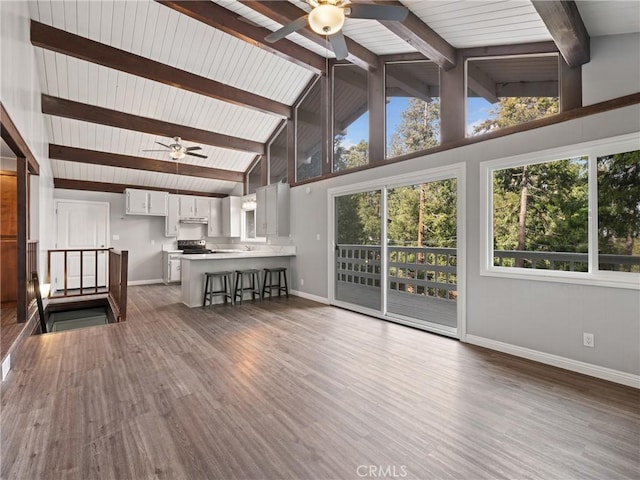 unfurnished living room with beamed ceiling, high vaulted ceiling, dark hardwood / wood-style floors, and ceiling fan