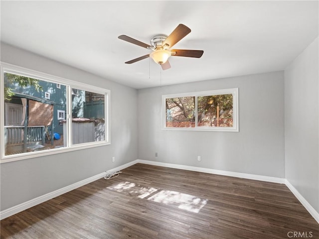 spare room featuring dark wood-type flooring and ceiling fan