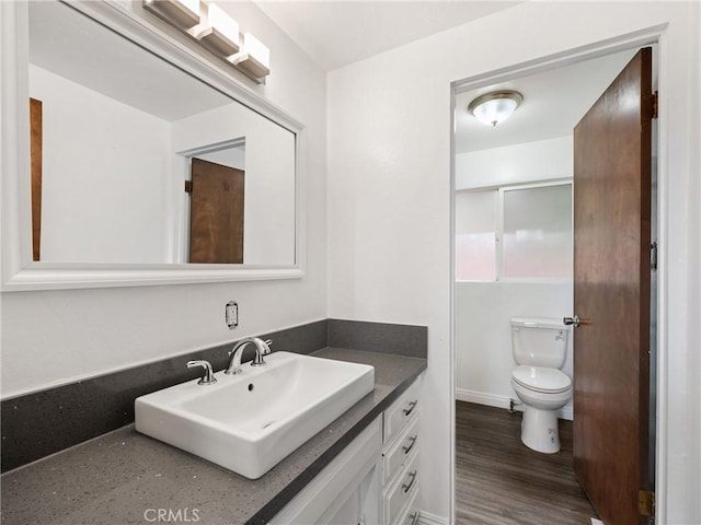 bathroom with hardwood / wood-style flooring, vanity, and toilet