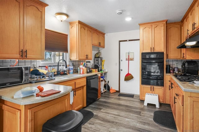 kitchen featuring tasteful backsplash, sink, dark wood-type flooring, and black appliances