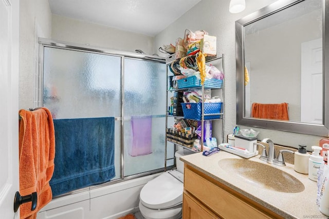 full bathroom with toilet, vanity, and bath / shower combo with glass door