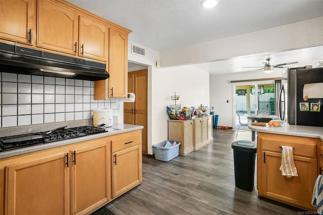 kitchen with stainless steel fridge, ceiling fan, black gas cooktop, dark hardwood / wood-style flooring, and decorative backsplash