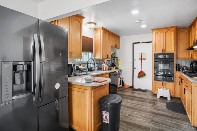 kitchen featuring tasteful backsplash, sink, dark hardwood / wood-style floors, and black appliances