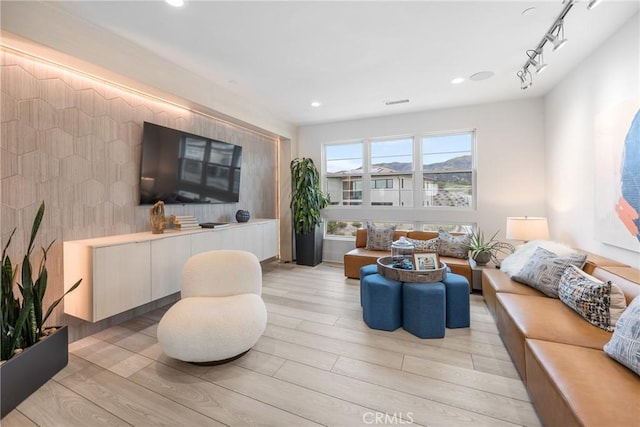 living room featuring track lighting and light hardwood / wood-style flooring