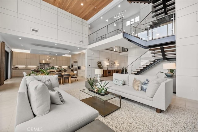 interior space with wooden ceiling, a high ceiling, tile walls, and light tile patterned floors