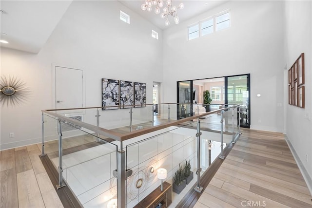 hall featuring a wealth of natural light, a chandelier, and light wood-type flooring