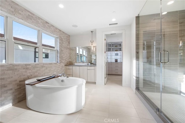 bathroom featuring vanity, tile patterned floors, tile walls, and separate shower and tub