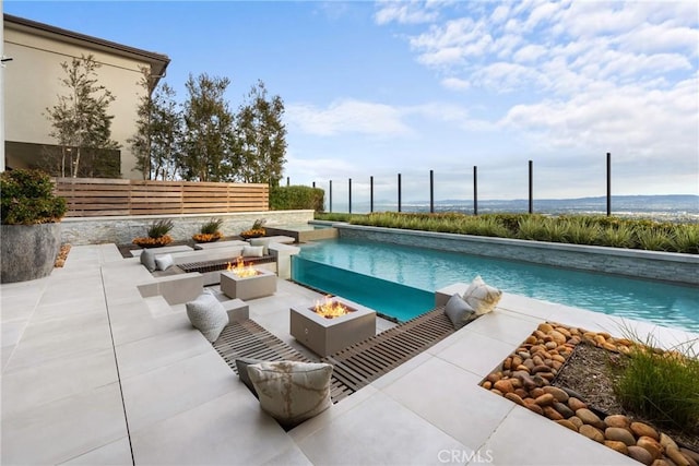 view of swimming pool with a fire pit and a patio area