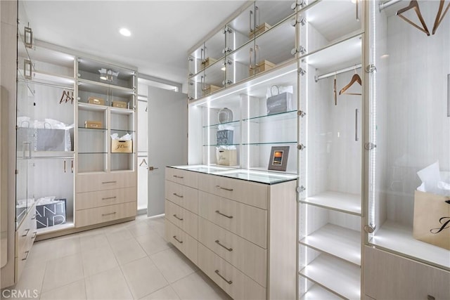 walk in closet with light tile patterned floors