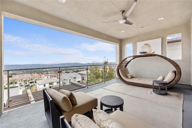 balcony with a mountain view, an outdoor hangout area, and ceiling fan