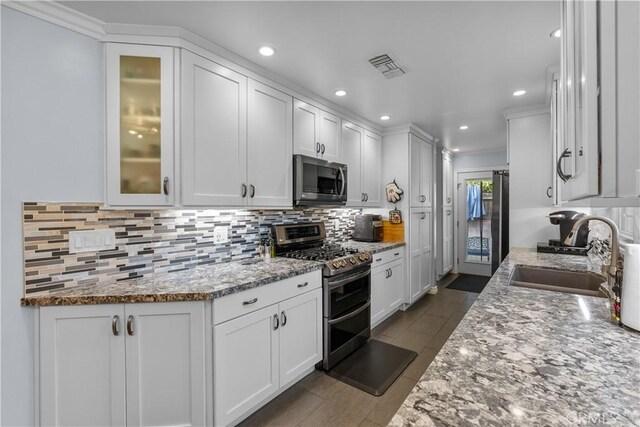 kitchen featuring sink, light stone countertops, white cabinets, and appliances with stainless steel finishes