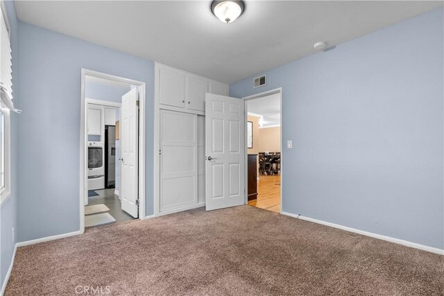 unfurnished bedroom featuring stainless steel refrigerator with ice dispenser, connected bathroom, light carpet, and a closet