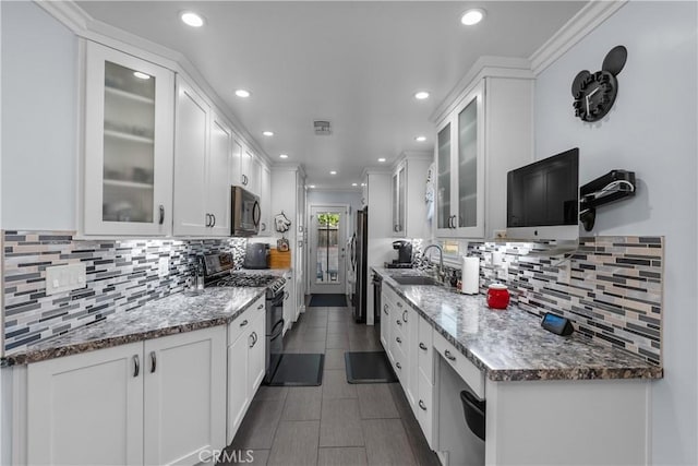 kitchen featuring range with two ovens, white cabinetry, light stone countertops, and stainless steel fridge