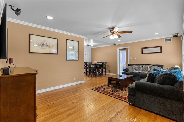 living room with ornamental molding, ceiling fan, and light hardwood / wood-style flooring