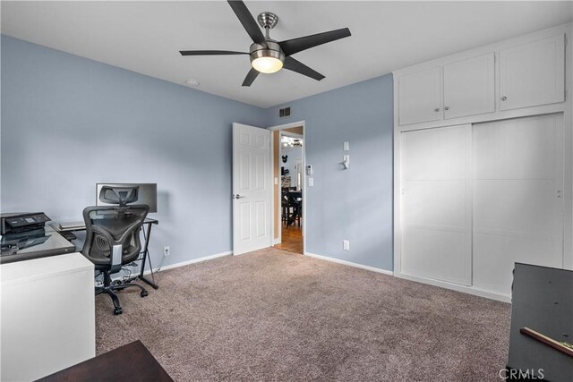 unfurnished office featuring light carpet and ceiling fan