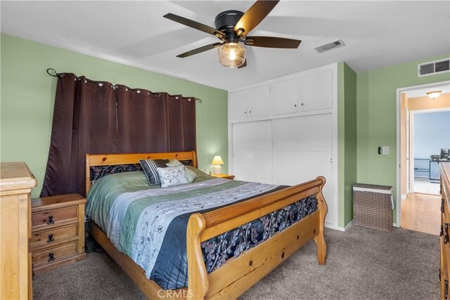 carpeted bedroom with ceiling fan and a closet