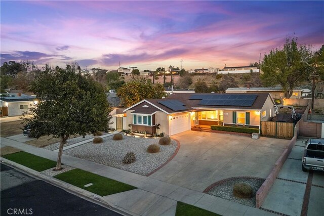 view of front of property with a garage and solar panels